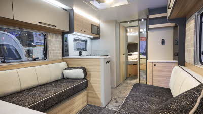 Interior of the Bailey Pegasus Black Amalfi with coffee and cream sofas, cosy cushions and wood accents, large windows and two skylights will let natural light flood in.  Perfect for relaxation and designed for comfort.