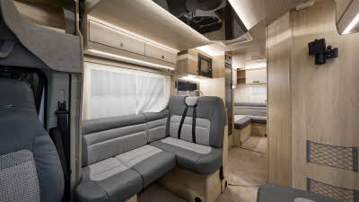 Auto-Trail F-Line F72's interior has two tone grey leather and fabric.  The furniture is wooden and two of the rear seats have fitted seat belts.  There is a lounge to the rear.
