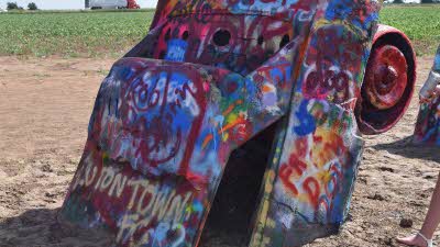 A very colourful Cadillac half in the ground as part of the Cadillac Range art installation