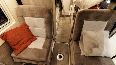 The WildAx Motorhomes Solaris XL two rear passenger seats are brown and cream.  They each have a cushion on them.  