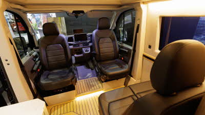 The Kaktus Adventure Vans Dune has black upholstery, the floor is wooden.  The front two seats are swivelled and are facing into the van.