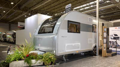 The Adria Altea Avon is silver and grey, complete with nearby plants and hanging signage, emphasising its contemporary design and outdoor comfort features.