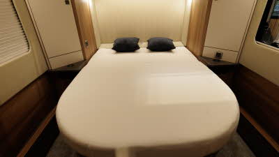 The Auto-Trail Frontier Comanche has a rear fixed island bed with two black cushions on either side.  There are two windows,