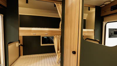 The Rimor Kilig 79 has two rear bunk beds each with a cream privacy curtain.
