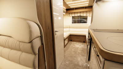 The Roller Team T-Line 700 has cream/beige upholstery with matching cabinets.  The kitchen is in the front right and to the rear there is a lounge with a u shaped sofa.