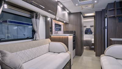 Buccaneer Commodore’s interior has cream and beige upholstery with dark wooden furniture.  There is a fixed island bed in the bedroom at the rear.  There is a window at the end of the caravan.  There are three roof lights.