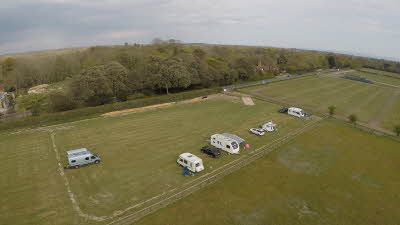 Open field with five caravans pitched up
